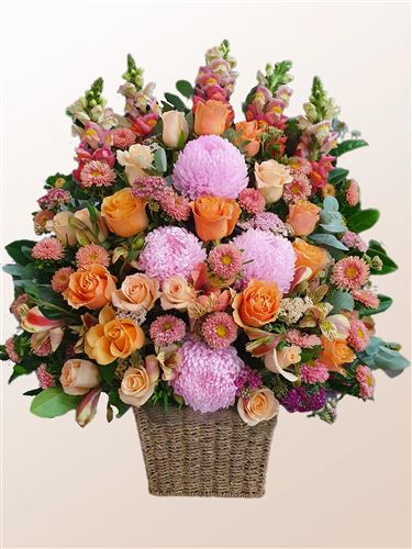 Simone, Basket arrangement of bright mixed flowers.